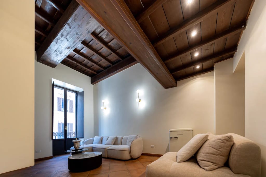 Zona giorno con travi a vista nella residenza vicino a Piazza di Spagna