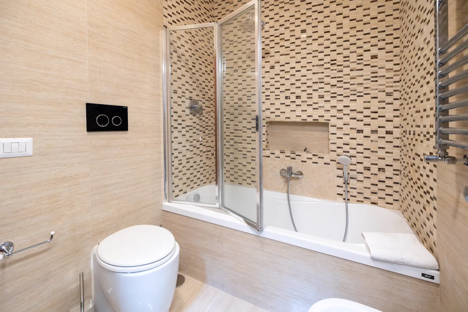 Bagno con rivestimenti chiari e doccia
